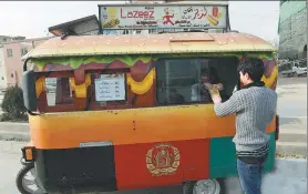  ?? SHAH MARAI / AGENCE FRANCE- PRESSE ?? An customer buys a burger from a Lazeez food truck in Kabul, Afghanista­n.
