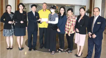  ??  ?? Ho (third left) hands over the donation to Wong witnessed by Ting (fourth left), Wong’s mother Liew Chin Moi (fourth right), Bong (third right) and staff of Dynasty Hotel