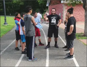  ?? Call photos/Ernest A. Brown ?? Above, Central Falls City Councilman Jonathan Acosta, center, who is also a youth wrestling coach, talks to members of his wrestling team about the race course and what to expect before the start of ‘The Test Run.’ Below, Anthony Hernandez, 17, of...