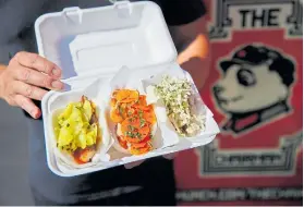  ?? NHAT V. MEYER/STAFF ?? Curtis Lam
(left) serves up his signature bao filled with pork belly, spicy chicken or CocaCola-braised pork from his popular food truck, as well as at his Levi’s Stadium stall.