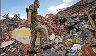  ?? ANDRII MARIENKO / AP ?? A Ukrainian serviceman looks at the rubble of a school that was destroyed some days ago during a missile strike in outskirts of Kharkiv, Ukraine on Tuesday.