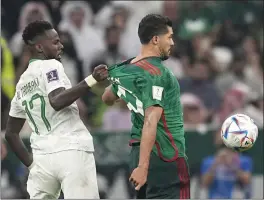  ?? EBRAHIM NOROOZI — THE ASSOCIATED PRESS ?? Saudi Arabia's Hassan Tambakti pulls the jersey of Mexico's Henry Martin during Wednesday's Group C match at the World Cup at Lusail Stadium in Lusail, Qatar.