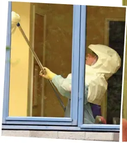  ??  ?? Mop up: Workers in protective clothing at the Waterbeach GP surgery in Cambridge, which has been closed for a deep-clean