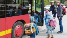  ?? Foto: Sebastian Mayr ?? Hauptkommi­ssar Robert Schlottere­r und Schulbusbe­gleiterin Gunhild Höner helfen Schulkinde­rn beim Einsteigen in den Bus.