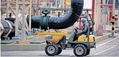  ?? | AFP ?? A WORKER drives a machine at the Enagas regasifica­tion plant at the Muelle de la Energia in Barcelona, Spain.