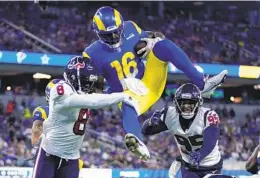  ?? ASHLEY LANDIS AP ?? Rams quarterbac­k Bryce Perkins (top) leaps over Texans safety Terrence Brooks during the second half of a Houston victory over Los Angeles on Friday night.