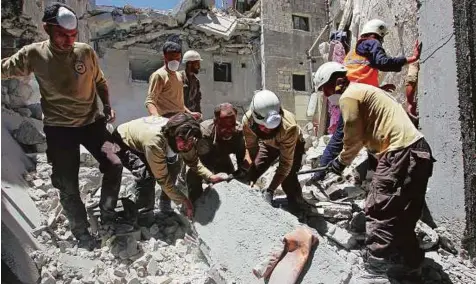  ?? Reuters ?? Civil defence personnel search for survivors at a site hit by air strikes in the rebel-controlled town of Ariha, Syria.