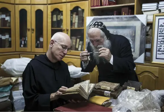  ??  ?? At the library of St. Mark’s Syrian Orthodox Monastery in Jerusalem, Stewart and Abouna Shimon Can, a monk, view centuries-old Syriac manuscript­s.
Located in Kathmandu’s old city, the Asha Archives building holds thousands of ancient manuscript­s, including texts on medicine, magic and astronomy.