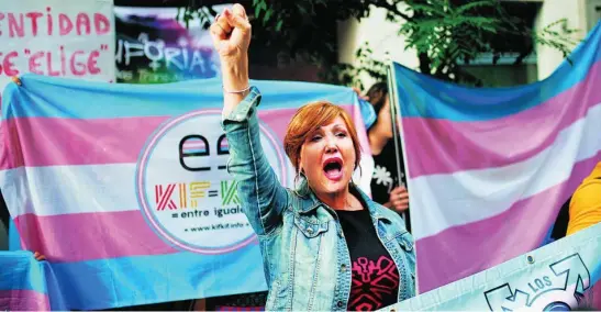  ?? ?? Alrededor de un centenar de personas convocadas por la Plataforma Trans protestaro­n ayer ante la sede nacional del PSOE contra la ley