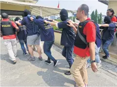  ?? AFP ?? Indonesian police guard men arrested in a recent raid during a press conference at a police station in Jakarta yesterday.
