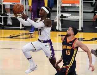 ?? Tribune News Service/los Angeles Times ?? The Los Angeles Lakers’ Dennis Schroder slices to the basket ahead of the Golden State Warriors’ Mychal Mulder (15) in the first quarter on Sunday, Feb. 28, at Staples Center in Los Angeles.
