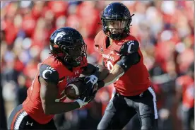  ?? AARON DOSTER — THE ASSOCIATED PRESS ?? Cincinnati running back Jerome Ford, left, takes the hand off from quarterbac­k Desmond Ridder during the first half of an NCAA college football game against UCF, Saturday, Oct. 16, 2021, in Cincinnati.