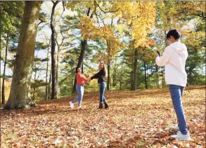  ?? Tyler Sizemore/Hearst Connecticu­t Media / Greenwich Time ?? Stamford's Mildia Chinchilla, center, poses in the colorful fall foliage with her daughter, Katherine Chinchilla, 18, as her son, Jefferson Chinchilla, 13, takes a photo at Bruce Park in Greenwich on Oct. 27, 2020.