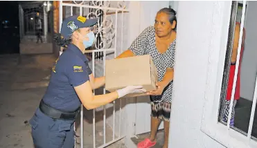  ?? CORTESÍA ?? Una mujer en el Atlántico recibe una de las cajas con ayuda alimentari­a.