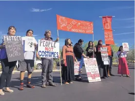  ?? TERRY TANG/ASSOCIATED PRESS ?? Native American protesters stand outside the Phoenix office of Yandy.com, a retailer of “sexy Native American” costumes, on Wednesday.