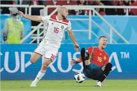  ?? PETR DAVID JOSEK THE ASSOCIATED PRESS ?? Spain’s Sergio Ramos, right, falls after a tackle by Morocco’s Noureddine Amrabat, left, during a World Cup Group B soccer match in Kaliningra­d, Russia, on Monday.