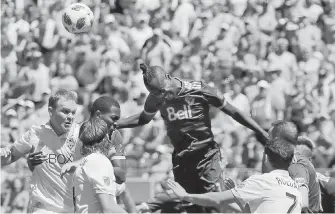  ??  ?? Vancouver Whitecaps forward Kei Kamara, centre, heads the ball after a corner kick by the Sounders during the second half of their MLS match on Saturday in Seattle.
