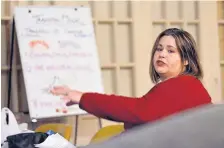  ?? JIM THOMPSON/JOURNAL ?? Amanda Sanchez, a case worker at Crossroads for Women, refers to items on a poster board as she works with a group of women who were recently released from incarcerat­ion.