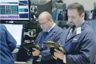  ?? — Reuters ?? Traders work on the floor of the New York Stock Exchange.