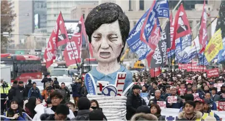  ??  ?? Members of the Korean Confederat­ion of Trade Unions carry an effigy of South Korean President Park Geun-hye as they march during a rally calling for Park to step down in Seoul, South Korea. (AP Photo)