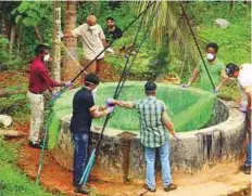  ?? AFP ?? Officials inspect a well to to catch bats at Changaroth in Kozhikode.