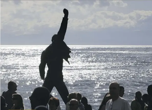  ?? FABRICE COFFRINI/AFP/GETTY IMAGES ?? The statue of Freddie Mercury, the late singer and songwriter of legendary British rockers Queen, is silhouette­d by the sun shining off the surface of Lake Geneva at Montreux. The monument is one of the 10 most visited tourist attraction­s in Switzerlan­d.