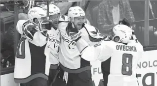  ?? FRANK GUNN, THE CANADIAN PRESS ?? From left, Marcus Johansson celebrates with teammates Justin Williams, Evgeny Kuznetsov and Alex Ovechkin after scoring the series-winning goal in overtime Sunday night in Toronto.