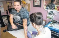  ?? CP PHOTO ?? Tattoo artist Lizzie Renaud, right , owner of Speakeasy Tattoo, outlines a stencil design on Sabrina Johnston before covering up her Hedley-inspired tattoo, in Toronto on Monday, March 12, 2018.