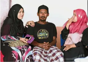  ?? — Bernama ?? Tragic incident: Family members comforting Mohd Fadzil as he waited to claim his children’s bodies. (Right) The suspect being led to the Teluk Intan magistrate’s court to be remanded.