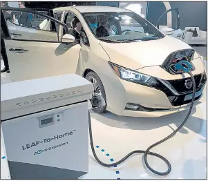  ?? Detroit Free Press/ERIC D. LAWRENCE ?? A 2018 Nissan Leaf is displayed at the Cobo Center in Detroit last month. The latest version of the Leaf electric vehicle can travel 150 miles on a charge.