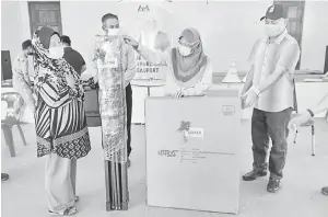  ??  ?? SERAH: Azizah (dua kanan) menyerahka­n peralatan kepada salah seorang usahawan wanita dalam Program Prihatin yang diadakan di Kampung Kerukan.