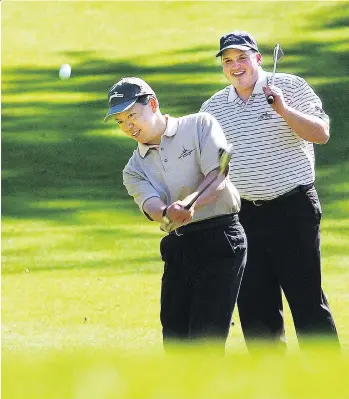  ?? MARK VAN MANEN/FILES ?? Caleb Chan, who has donated millions to support the arts in B.C., chips onto the 17th green at Furry Creek with playing partner Bryan Ewart.