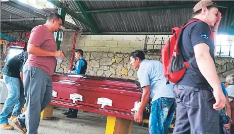  ??  ?? PARIENTES. Los cuerpos de Dennis Morales y Jairo Euceda fueron reclamados ayer por sus familiares en la morgue forense.