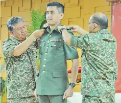  ??  ?? Ahmad Hasbullah and his deputy Lieutenant General Dato’ Hasagaya Bin Abdullah pinning the rank promotion pins on Colonel Al Hambra Tun Juhar.