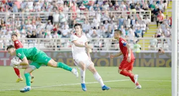  ?? — AFP photo ?? Vietnam’s goalkeeper Van Lam Dang (left) gathers the ball ahead of Iran’s forward Sardar Azmoun (centre) during the 2019 AFC Asian Cup group D football match between Vietnam and Iran at the al-Nahyan Stadium in Abu Dhabi.