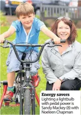  ??  ?? Energy savers Lighting a lightbulb with pedal power is Sandy Mackey (8) with Noeleen Chapman