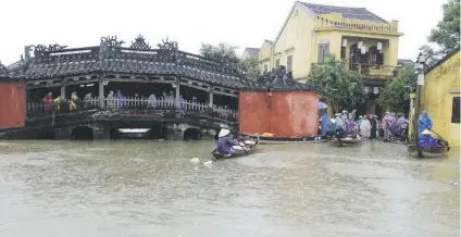  ?? Picture: AFP ?? SAILING DOWN THE HIGH STREET. Local residents navigate boats in the flooded tourist town of Hoi An yesterday a day after Typhoon Damrey made landfall in central Vietnam.