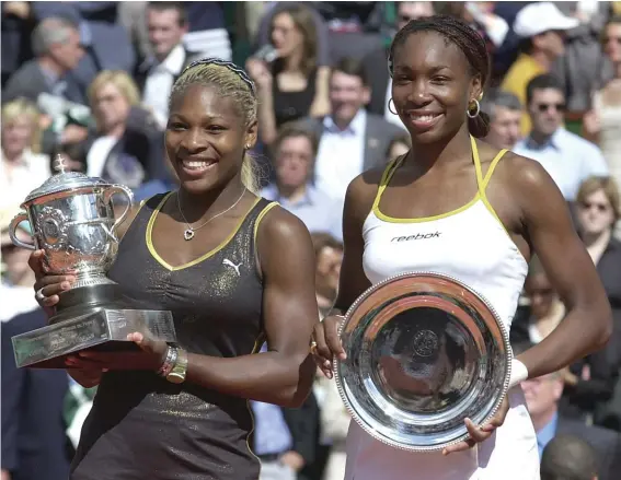  ??  ?? In this June 8, 2002, file photo, Serena Williams, left, and her sister Venus hold their trophies after the women's final of the French Open tennis tournament at Roland Garros stadium in Paris. Serena won 7-5, 6-3. (AP Photo/Francois Mori, File)