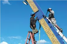  ?? Staff photo by Hunt Mercier ?? ■ Oscar Hernandez and Gerardo Melchor Herrera work on putting together one of the rides at Four States Fair Park Midway on Thursday in Texarkana, Ark.