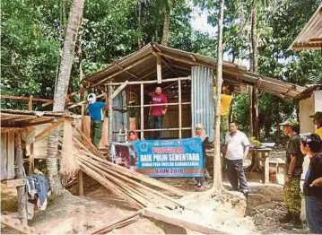  ??  ?? SUKARELAWA­N bergotong-royong membina rumah baru untuk keluarga Ruslida.