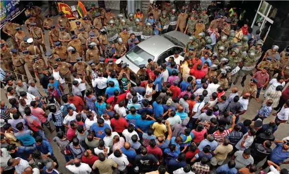  ?? Photo: EPA ?? A crowd gathers outside the state-run Ceylon Petroleum Corporatio­n office in Colombo, where the shooting took place.