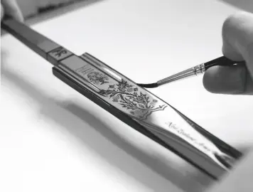  ??  ?? Above left: A 1912 cavalry officer’s sword, with the regimental crest etched on the blade. Above: Handpainti­ng the 2019 Pooley Sword of Honour for the Edinburgh Military Tattoo. Below left: A sword of the Royal Engineers. Below: Screenprin­ting a design onto a blade