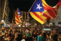  ?? SEAN GALLUP, GETTY IMAGES ?? People wave Catalan independen­ce flags after listening to a Saturday night statement by Catalan regional president Carles Puigdemont.