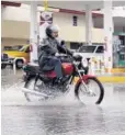  ?? FOTO: RICARDO NEVÁREZ ?? &gt; Motociclis­ta evade el agua para no mojarse.