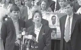  ?? PETER ANDREW BOSCH Miami Herald File ?? Caroline Heck Miller talks to the press in 2001 about the guilty verdicts handed five men in the spy and murder case. Flanking Miller are assistant U.S. attorneys John Kastrenake­s, left, and David Buckner, right. Family members and friends of the four killed in the shoot-down of Brothers to the Rescue planes stand behind them.