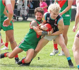  ?? Photograph­s by AMANDA EMARY. ?? Cora Lynn’s Liam Taylor wrestles with Tooradin-Dalmore’s James Wheeler to keep hold of the ball in the reserves.