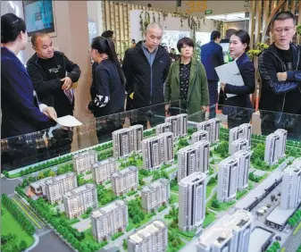  ?? WEI LIANG / CHINA NEWS SERVICE ?? Potential homebuyers look at property models during a real estate expo in Taiyuan, capital of Shanxi province.