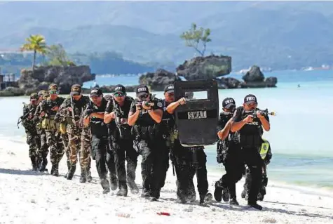  ?? Reuters ?? ■ Members of the police SWAT team during a hostage-taking drill, a day before the temporary closure of Boracay, in the Philippine­s yesterday. The police have been doing exercises on the beach, preparing for resistance that residents say is highly...