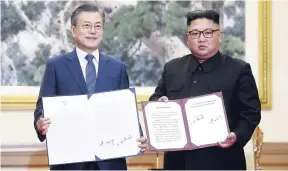  ?? AP ?? South Korean President Moon Jae-in (left) and North Korean leader Kim Jong-un hold documents after signing at the Paekhwawon State Guesthouse in Pyongyang, North Korea, yesterday.