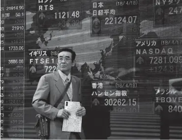  ?? PHOTO: AP PHOTO/SHIZUO KAMBAYASHI ?? A man walks past an electronic stock indicator of a securities firm in Tokyo yesterday. If global business confidence falters as a result of Gray Rhino’s such as tighter monetary policies, inflation fears and global trade tensions rest assured that...